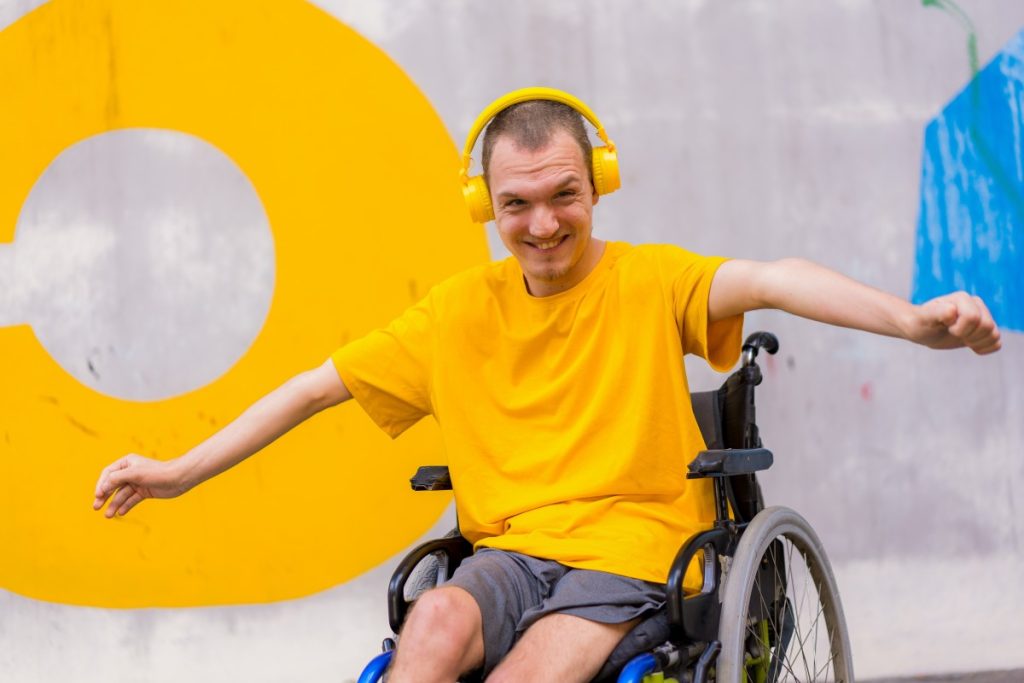Disabled man in wheelchair smiling happily at the camera